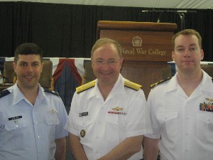 Lt. Col. Andrew J. Gebara, USAF (l), and Lt. Cmdr. Kalohi R. Clark, USN (r), are recognized for their award-winning essays by Rear Adm. James P. 